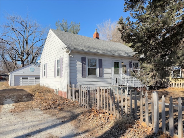 view of front of home with a garage and an outbuilding