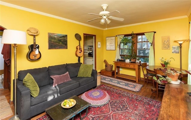 living room with wood-type flooring, ornamental molding, and ceiling fan