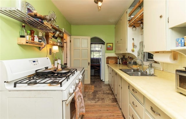 kitchen with white cabinetry, white appliances, and sink