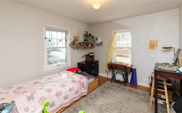 bedroom with hardwood / wood-style floors and multiple windows