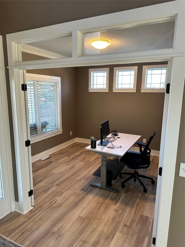 office space with wood-type flooring and a textured ceiling