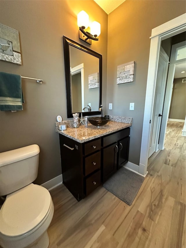 bathroom featuring toilet, wood-type flooring, and vanity