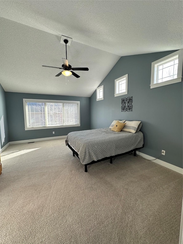 carpeted bedroom featuring vaulted ceiling, ceiling fan, a textured ceiling, and multiple windows