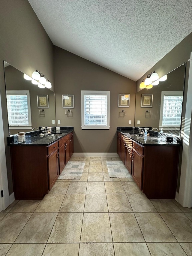 bathroom featuring a textured ceiling, tile patterned floors, vanity, and lofted ceiling