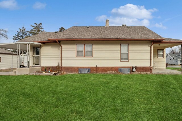 rear view of property featuring a lawn