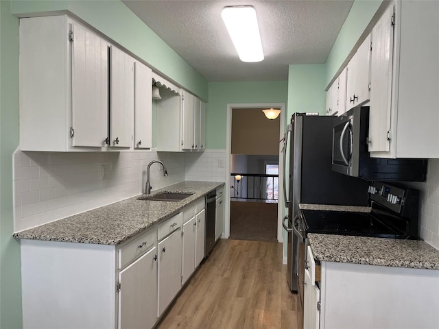 kitchen featuring sink, white cabinetry, a textured ceiling, and appliances with stainless steel finishes