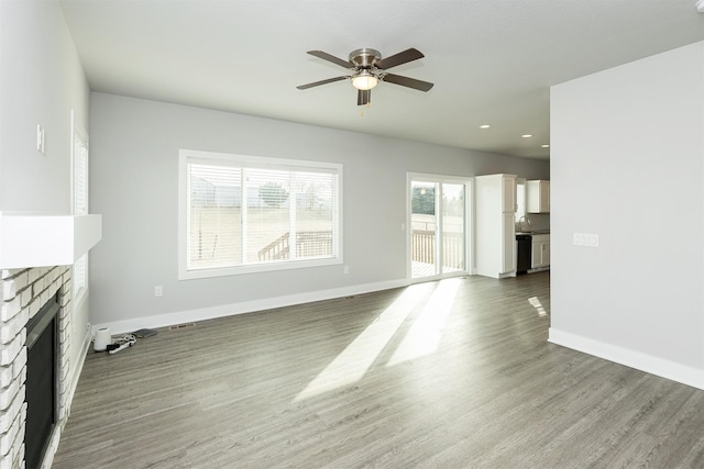 unfurnished living room featuring ceiling fan, dark hardwood / wood-style floors, and a fireplace