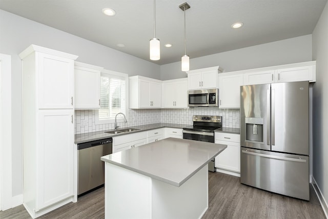 kitchen with sink, stainless steel appliances, white cabinets, and a kitchen island