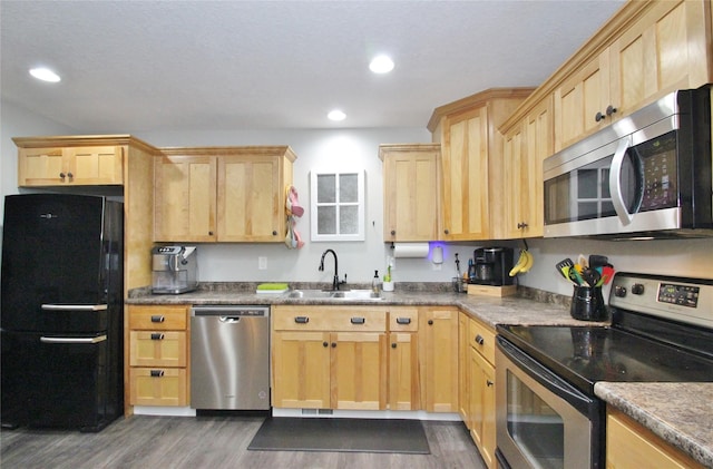 kitchen with appliances with stainless steel finishes, dark hardwood / wood-style flooring, sink, and light brown cabinets