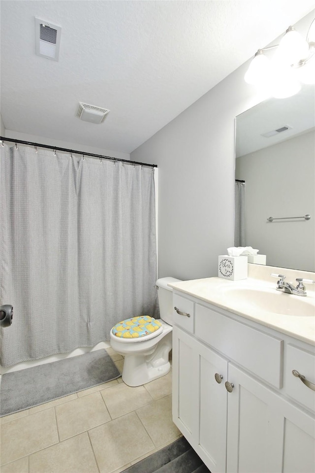 full bathroom with shower / bath combo, tile patterned flooring, vanity, and toilet