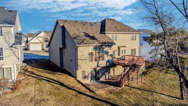 back of property with a wooden deck and a lawn