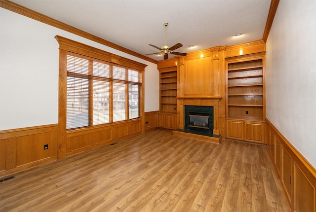 unfurnished living room featuring ornamental molding, light hardwood / wood-style floors, and built in features