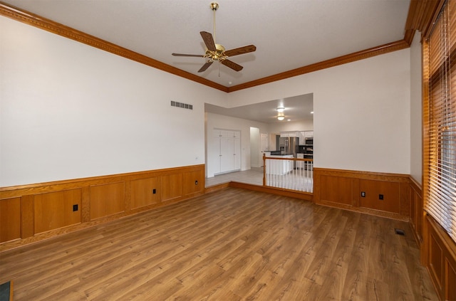 unfurnished living room with crown molding, ceiling fan, and wood-type flooring