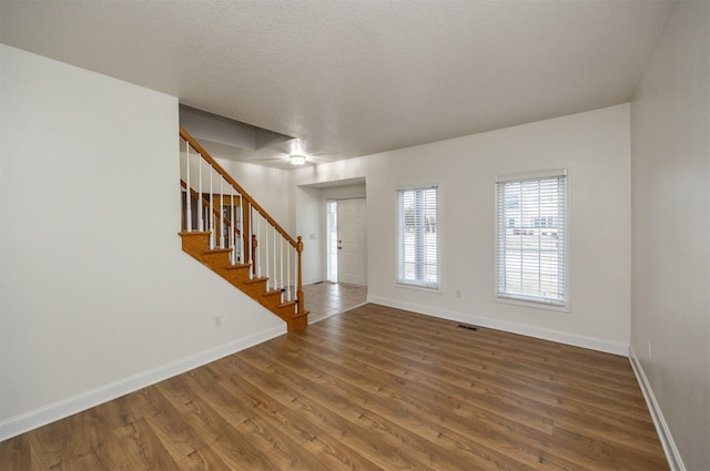 entrance foyer with hardwood / wood-style floors and a textured ceiling