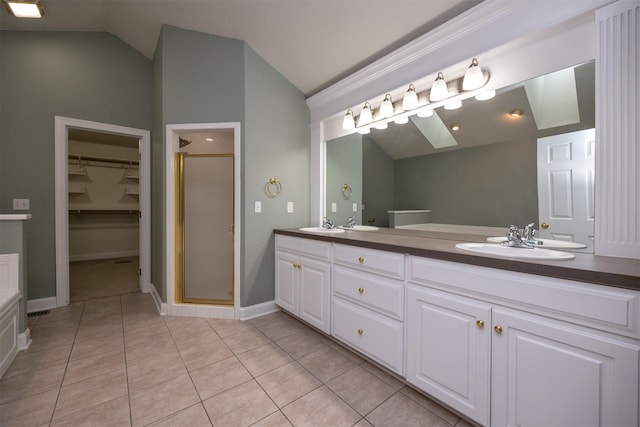 bathroom with vanity, tile patterned flooring, a shower with shower door, and lofted ceiling with skylight