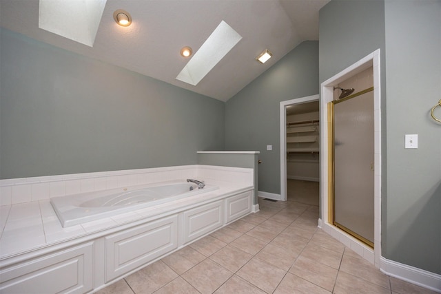 bathroom with independent shower and bath, lofted ceiling with skylight, and tile patterned floors