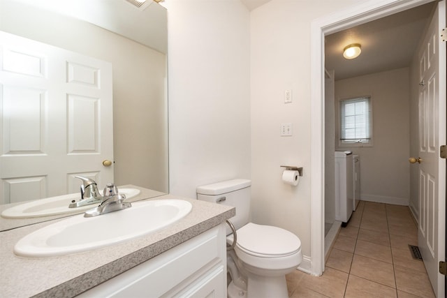 bathroom with tile patterned floors, toilet, separate washer and dryer, and vanity