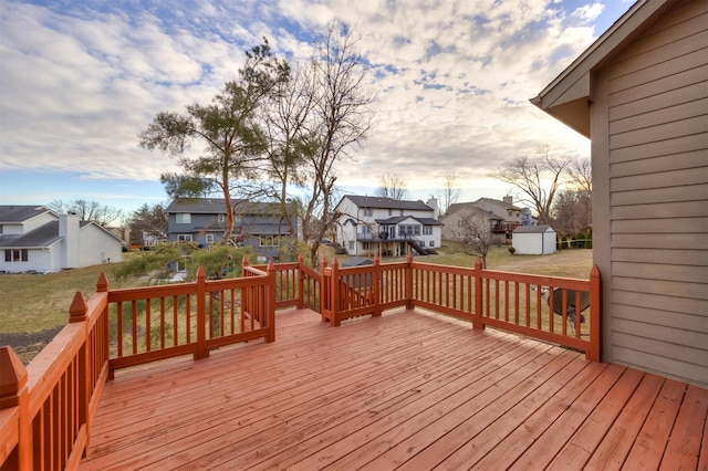 deck at dusk featuring a storage shed and a yard