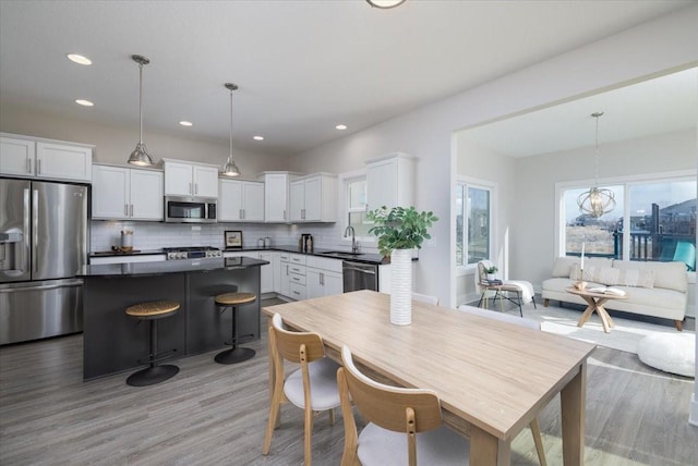 kitchen with sink, decorative light fixtures, white cabinets, and appliances with stainless steel finishes