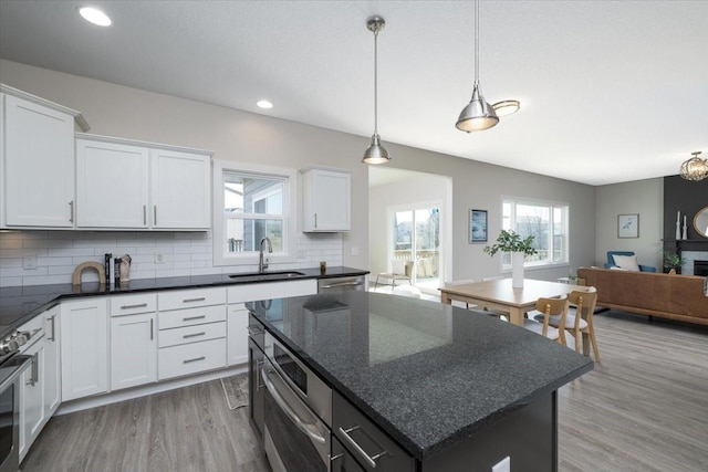 kitchen featuring sink, white cabinets, backsplash, and a kitchen island