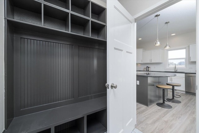 mudroom with sink and light hardwood / wood-style floors