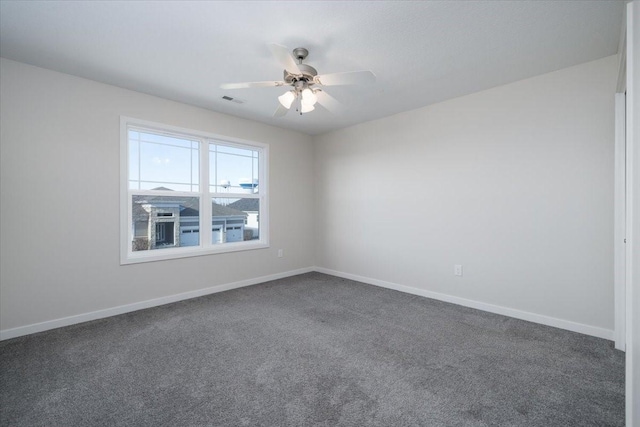 empty room featuring ceiling fan and dark carpet