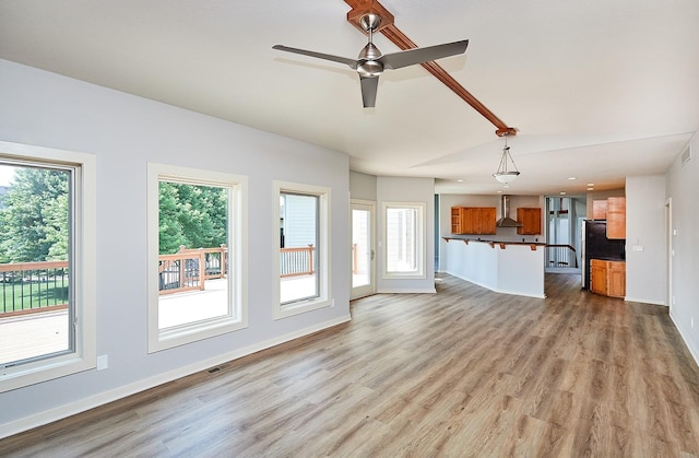 unfurnished living room with light wood finished floors, visible vents, baseboards, lofted ceiling, and ceiling fan