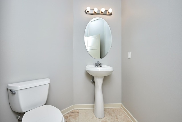 half bath featuring tile patterned flooring, baseboards, and toilet