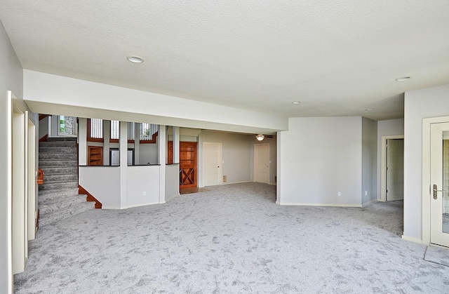 interior space with carpet, a textured ceiling, stairway, and baseboards