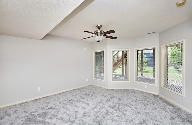 spare room featuring ceiling fan, a textured ceiling, baseboards, and carpet flooring