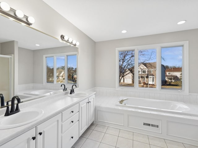 bathroom featuring vanity, tile patterned flooring, and a washtub