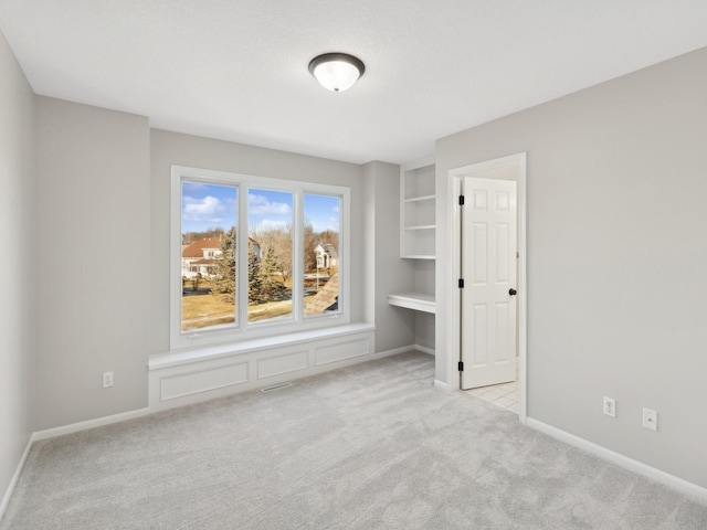 carpeted empty room with built in features