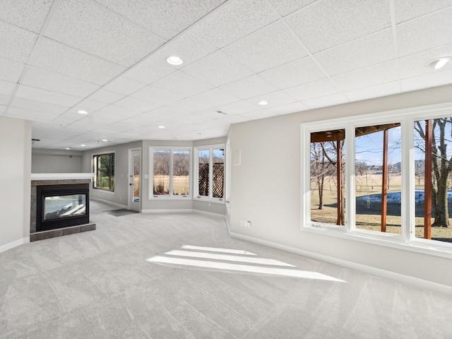 unfurnished living room featuring a fireplace, light carpet, and a healthy amount of sunlight