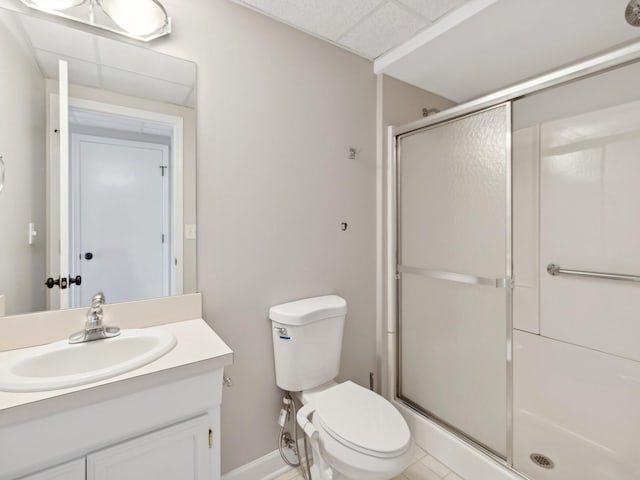 bathroom featuring toilet, a shower with shower door, a paneled ceiling, and vanity