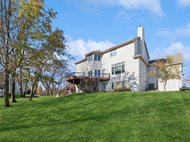 rear view of property with a yard, a wooden deck, central air condition unit, and a shed