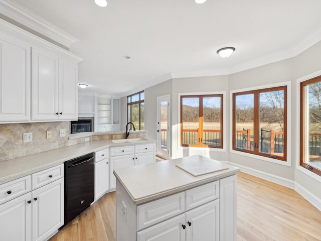 kitchen featuring sink, white cabinetry, black dishwasher, and a center island