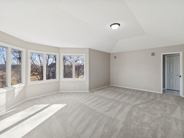 carpeted spare room with lofted ceiling