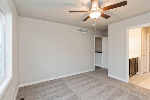 unfurnished bedroom featuring baseboards, visible vents, and light colored carpet