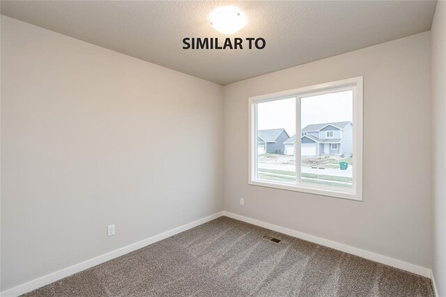 spare room with carpet, visible vents, and baseboards