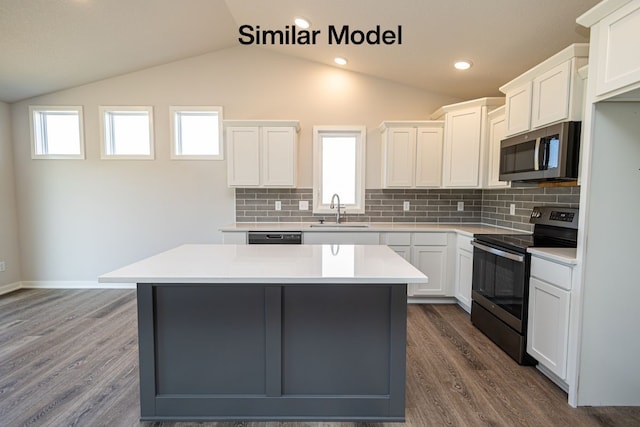 kitchen featuring white cabinets, appliances with stainless steel finishes, a center island, and sink