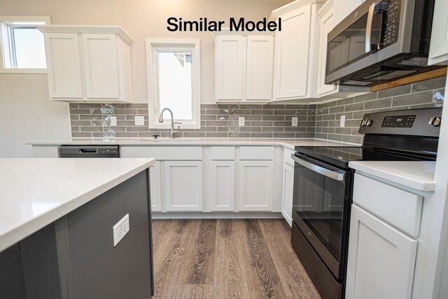 kitchen featuring dark hardwood / wood-style flooring, sink, stainless steel appliances, and white cabinetry