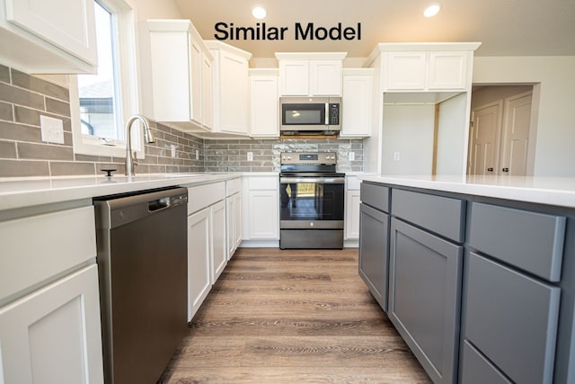 kitchen with stainless steel appliances, gray cabinetry, decorative backsplash, white cabinets, and sink