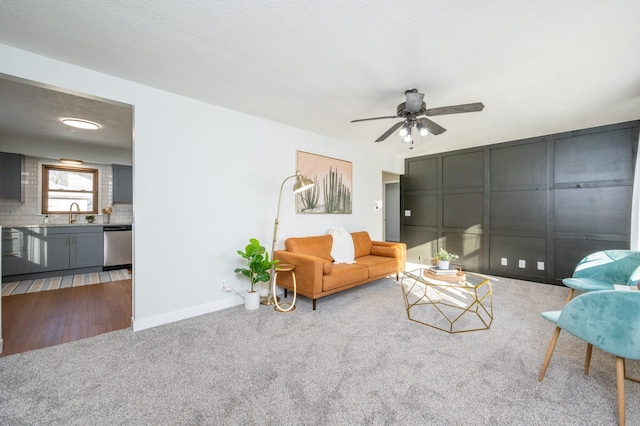 carpeted living room featuring sink, a textured ceiling, and ceiling fan