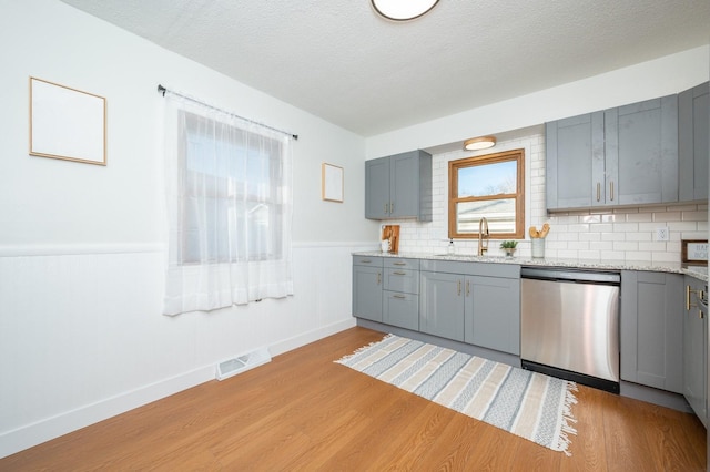 kitchen featuring gray cabinets, dishwasher, and sink