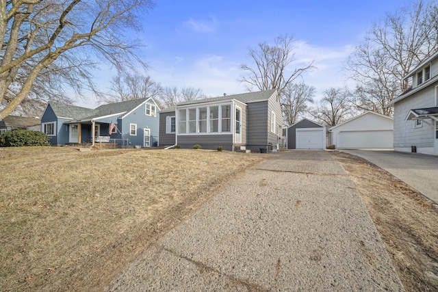 view of front of property with a front yard, covered porch, a garage, and an outdoor structure