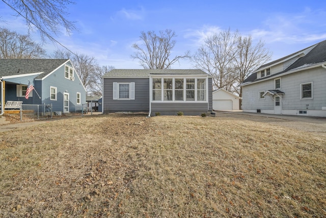 back of property featuring a garage, an outbuilding, and a lawn