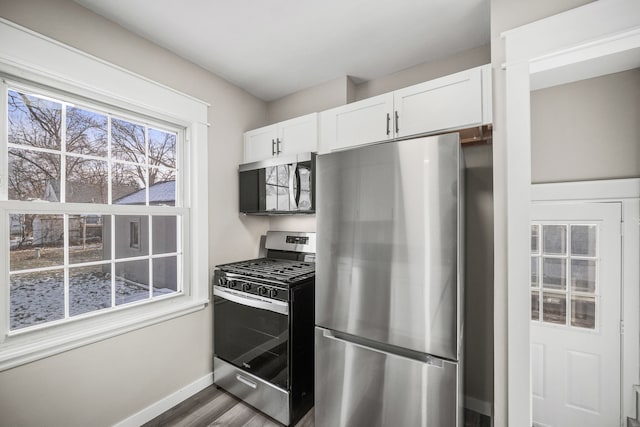 kitchen featuring wood-type flooring, white cabinetry, and appliances with stainless steel finishes