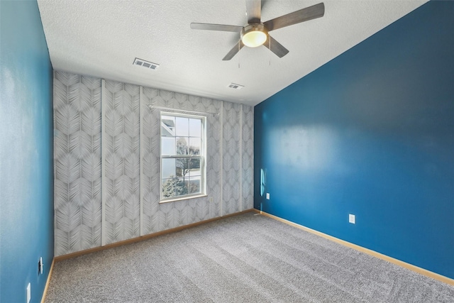 carpeted empty room featuring a textured ceiling and ceiling fan