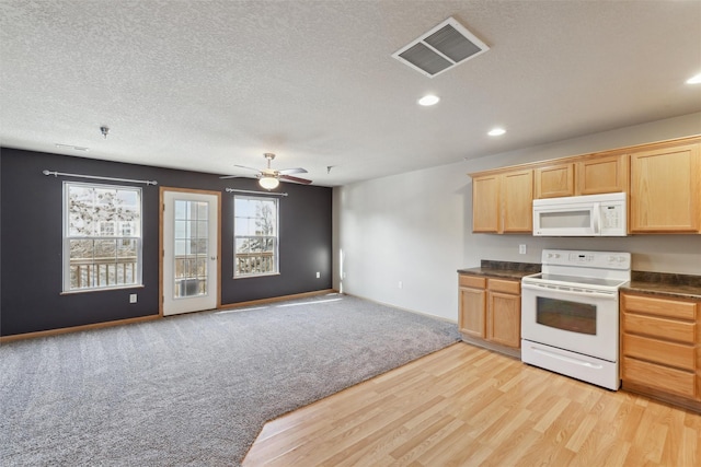 kitchen featuring a textured ceiling, white appliances, ceiling fan, light brown cabinetry, and light colored carpet