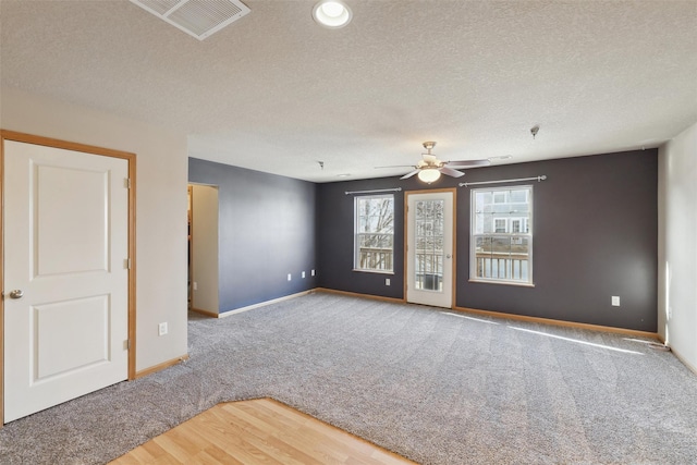 carpeted empty room with a textured ceiling and ceiling fan